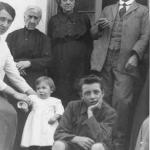 Mario, a year and a half old, with white smock, between mother and brother Toni, behind the grandparents.